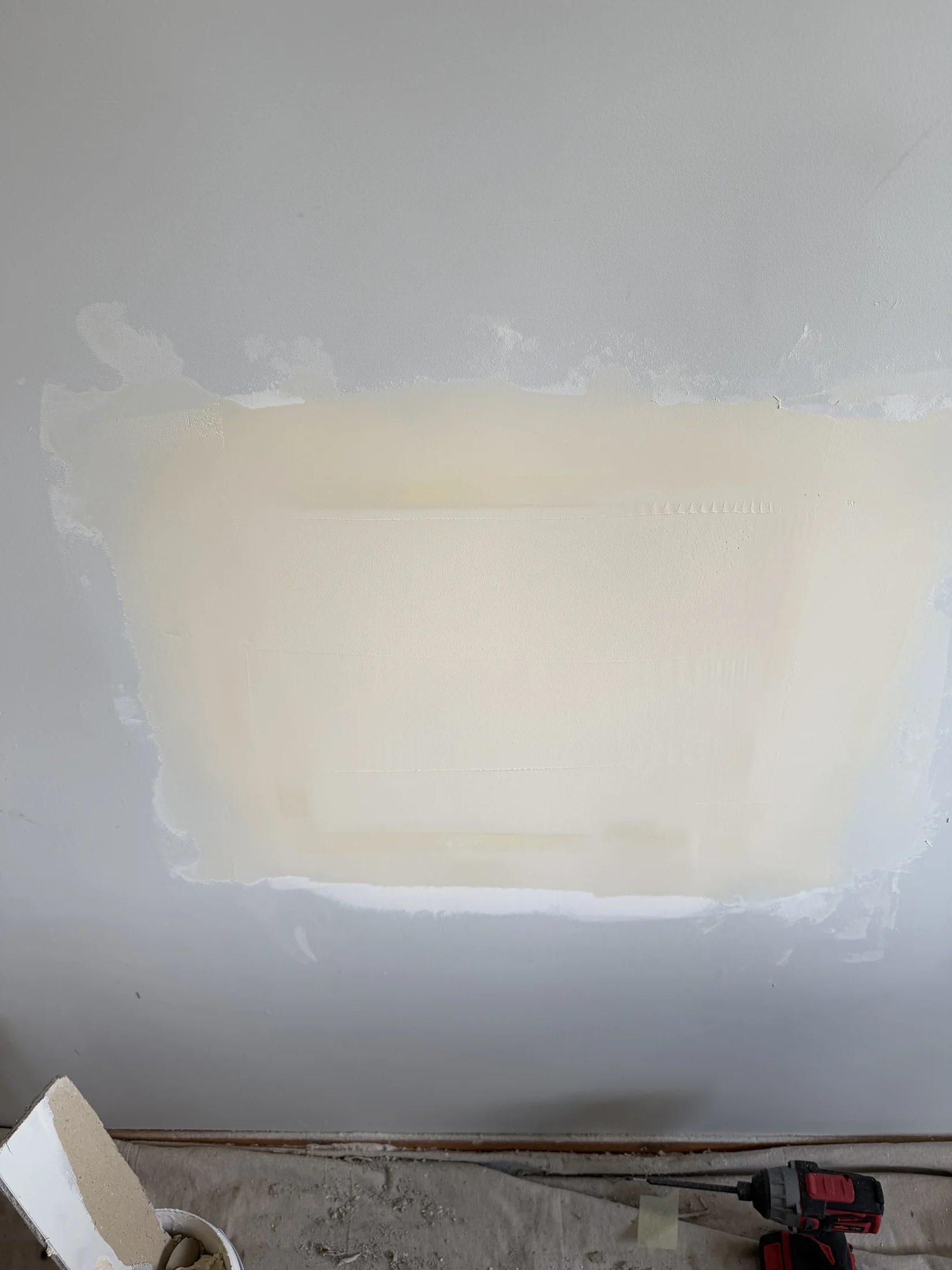 Wall patch plastered and sanded smooth — edges feathered wide