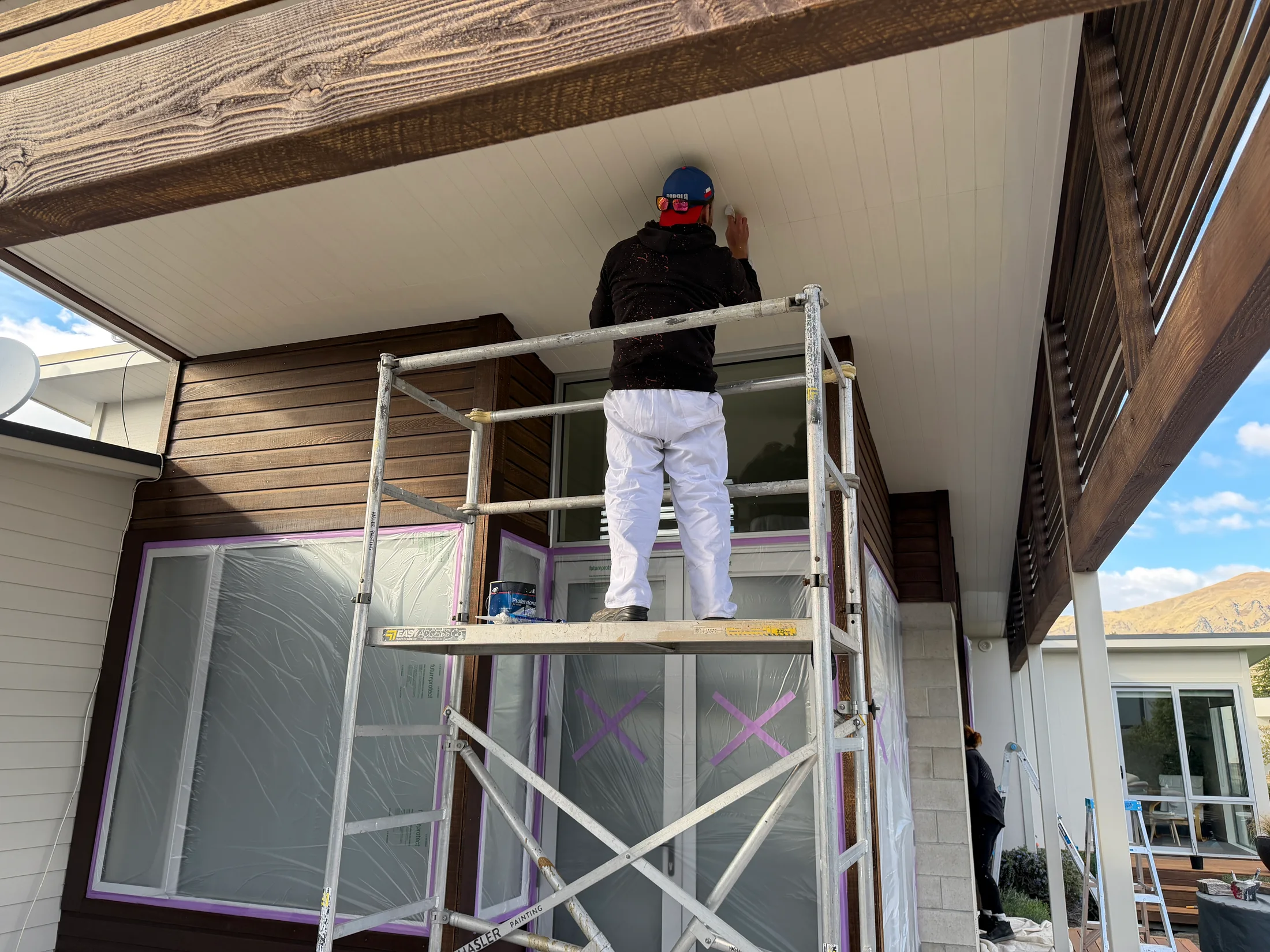 Exterior Repaint & Cedar Maintenance, Wānaka - Process 3: Painting Soffit Above Masked Windows Wanaka