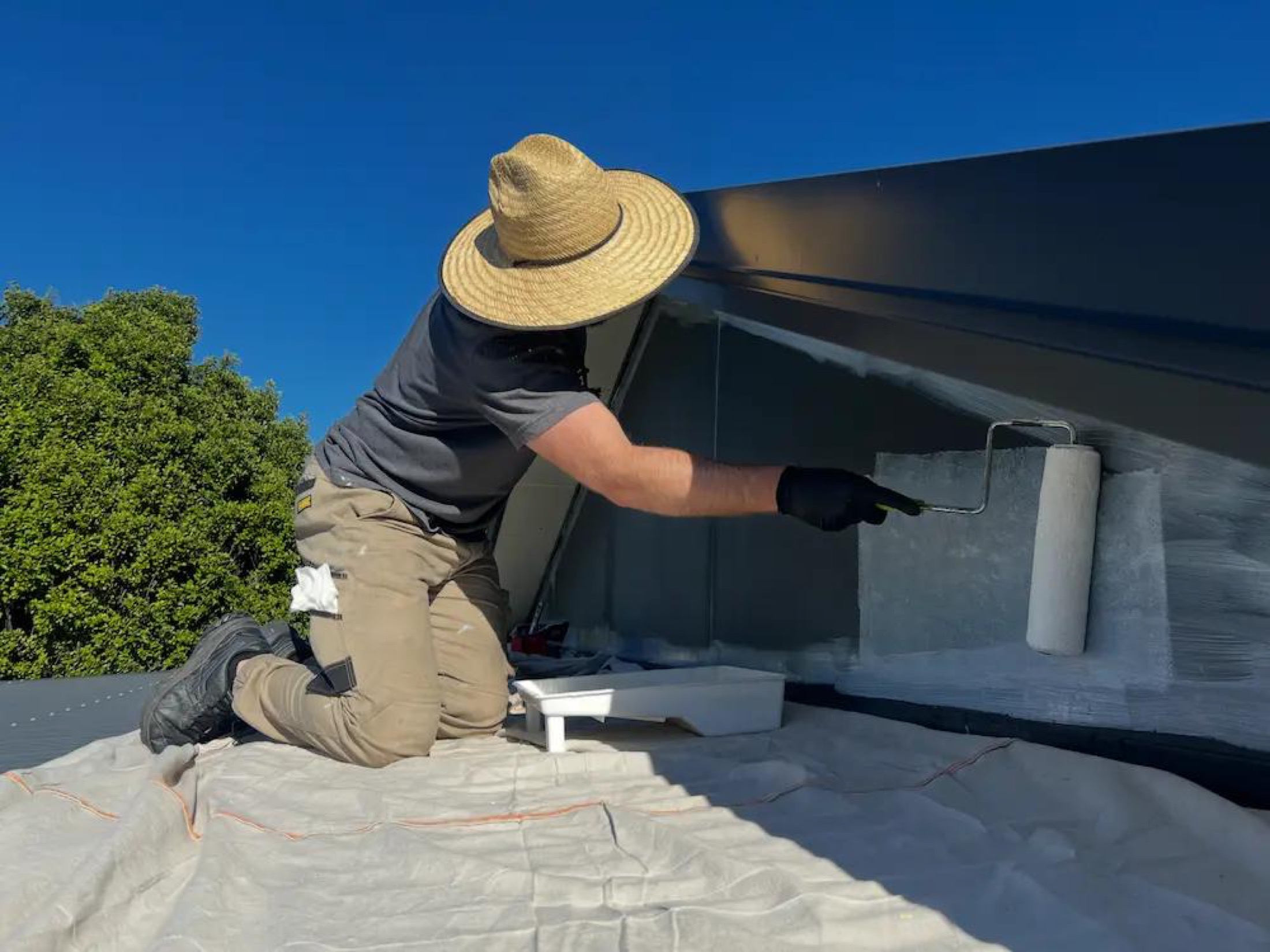 Repaint of Gables in Wanaka - Process 2: Painter Rolling Gable End On Roof Wanaka